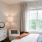 Large well lit bedroom with plush carpets and large windows 