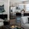 Spacious and well lit living room with wood flooring, large windows and open access to the kitchen